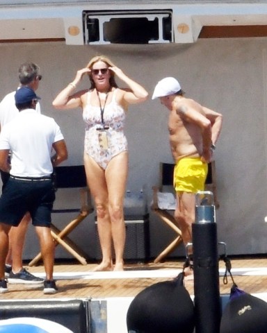 Elba, ITALY  - *EXCLUSIVE*  - Sir Rod Stewart, 77, and wife Penny Lancaster, 51, enjoy the Tuscan Sun while vacationing on Elba Island. Rod has been enjoying his vacation with wife of 15 years, Penny and their son. Rod still very much a gentleman, was seen extending his hand to Penny to help her as she climbed up the ladder after a dip in the sea.  On Monday the superstar shared a family photo with 7 of his 8 children.The Downtown Train singer was spotted relaxing while enjoying a day aboard the St. David on the Mediterranean. The super yacht comes with every luxury amenity including fully equipped gym, jacquzzi, and tons of toys at the ready including wave runners, sea bobs, wakeboards, kayaks and of course an large inflatable raft which Rod seemed to enjoy quite a bit!Pictured: Rod Stewart, Penny Lancaster BACKGRID USA 4 AUGUST 2022 USA: +1 310 798 9111 / usasales@backgrid.comUK: +44 208 344 2007 / uksales@backgrid.com*UK Clients - Pictures Containing ChildrenPlease Pixelate Face Prior To Publication*