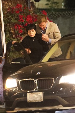 West Hollywood, CA - *EXCLUSIVE* - Liza Minnelli is helped by her carer and friend as she leaves Il Piccolo restaurant after having dinner with actor George Hamilton in West Hollywood.  The 76-year-old actress was seen being escorted from the restaurant in a wheelchair.  At one point, the caregiver and friend had a bit of a hard time getting Liza into the car, but it worked out in the end.  After dinner, Liza and George chatted for 5 minutes before parting.  Pictured: Liza Minnelli, George Hamilton BACKGRID USA March 21, 2022 US: +1 310 798 9111 / usasales@backgrid.com UK: +44 208 344 2007 / uksales@backgrid.com * Customer Vuong UK - Pictures with Children Please focus on faces before Publication*