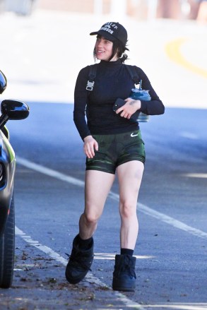 EXCLUSIVE: Billie Eilish looks super fit and body confident after confirming her new romance with The Neighborhood rocker Jesse Rutherford.  The 20-year-old hitmaker showed off her trim and toned physique in Nike bike shorts at a Los Angeles gym with a friend on Wednesday.  She looked cool in a Harley Davidson baseball cap and wore chunky black boots, also sporting three bruises on one leg.  After going public with her new 31-year-old boyfriend this week, she was all smiles, showing a peace sign and looking excited for her session.  Billy was accompanied by tattooed trainer Christina Neckia, who describes herself on social media as a 