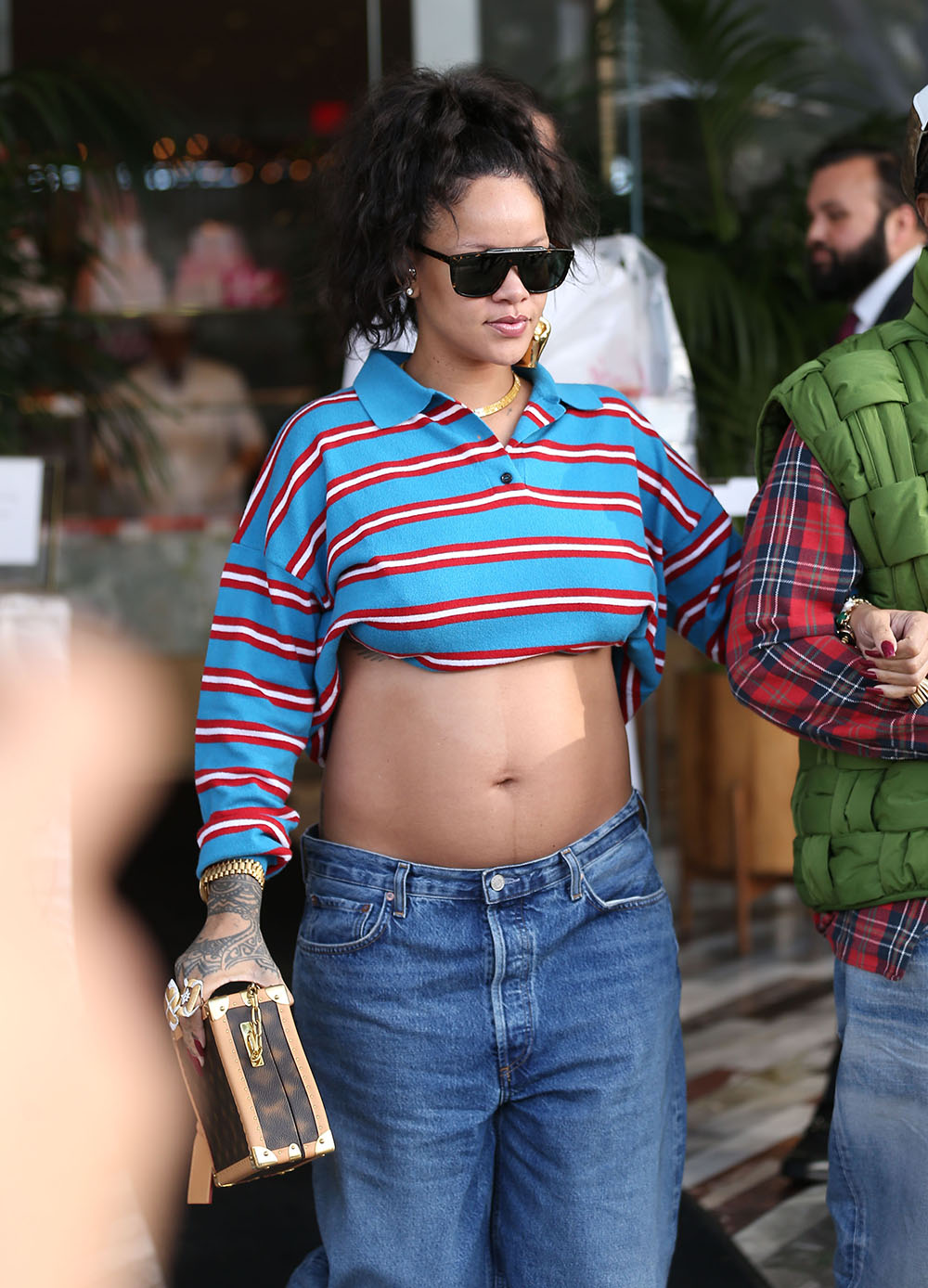 Chrissy Teigen looks cool in a cardigan, sports bra and baggy