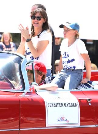 Jennifer Garner and her son Samuel celebrate the 4th of July in the community parade in a red convertible.  04 Jul 2022 Pictured: Jennifer Garner and Samuel.  Photo credit: APEX / MEGA TheMegaAgency.com +1 888 505 6342 (Mega Agency TagID: MEGA874723_009.jpg) [Photo via Mega Agency]