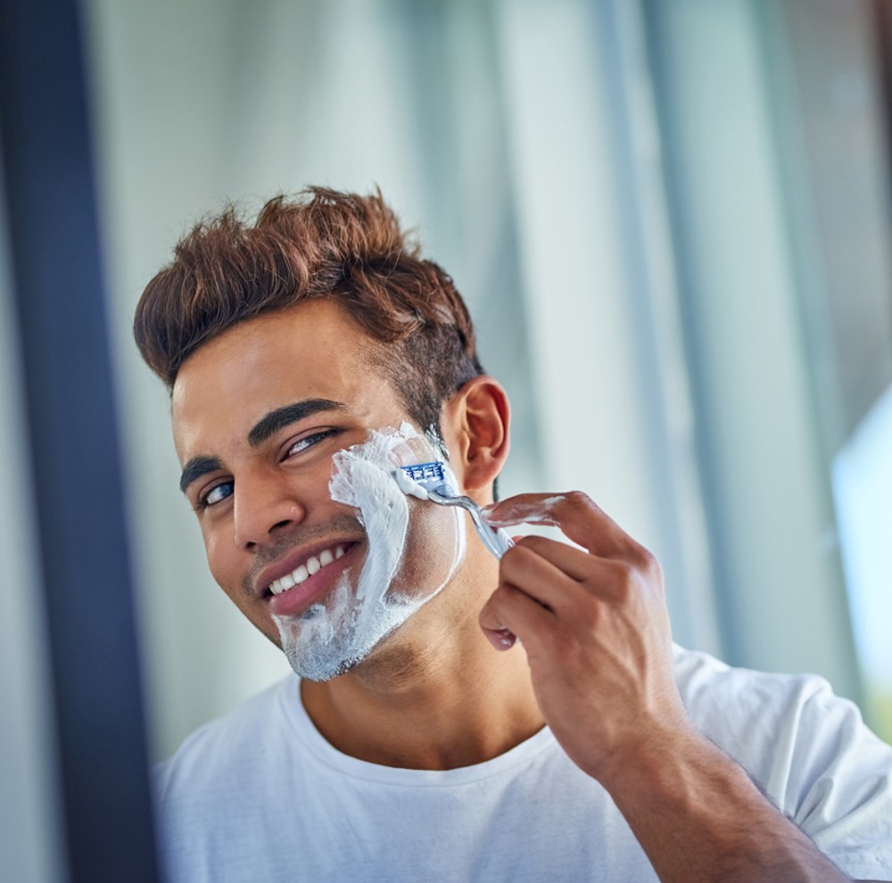 A man shaving his face with a safety razor