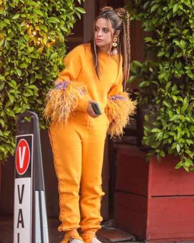 Santa Monica, CA  - *EXCLUSIVE*  - Camila Cabello wears a cozy orange sweats outfit with pom-pom-like sleeves and a few braids in her hair, as she and her mother Sinuhe are out for dinner in Santa Monica.  Pictured: Camila Cabello   BACKGRID USA 25 JUNE 2022   BYLINE MUST READ: BACKGRID  USA: +1 310 798 9111 / usasales@backgrid.com  UK: +44 208 344 2007 / uksales@backgrid.com  *UK Clients - Pictures Containing Children Please Pixelate Face Prior To Publication*