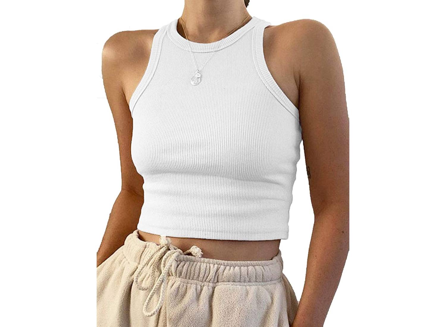 Woman model wearing a white, ribbed cropped tank top with beige pants