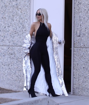 EXCLUSIVE: Kim Kardashian puts on a silver trench coat as she arrives for a Skims shoot in LA. 28 May 2022 Pictured: Kim Kardashian. Photo credit: MEGA TheMegaAgency.com +1 888 505 6342 (Mega Agency TagID: MEGA862959_016.jpg) [Photo via Mega Agency]