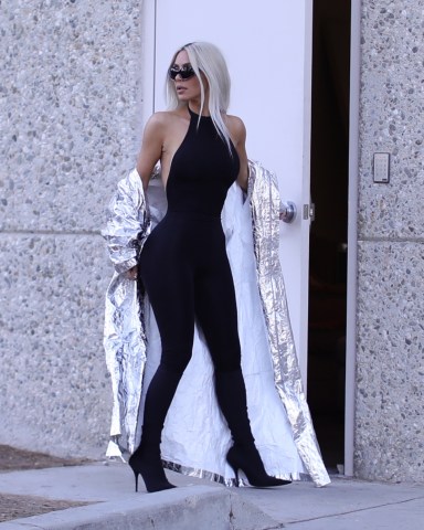 EXCLUSIVE: Kim Kardashian puts on a silver trench coat as she arrives for a Skims shoot in LA. 28 May 2022 Pictured: Kim Kardashian. Photo credit: MEGA TheMegaAgency.com +1 888 505 6342 (Mega Agency TagID: MEGA862959_016.jpg) [Photo via Mega Agency]
