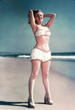 Editorial use onlyMandatory Credit: Photo by Snap/Shutterstock (390853hm)FILM STILLS OF 1947, BATHING SUIT, BEACH, CLOTHING, MARILYN MONROE, OCEAN, PIN-UPS, BIKINI, TWO PIECE, OUTSIDE, SAND, MIDRIFF, SHOES, FULL LENGTH, ARMS BEHIND HEAD IN 1947VARIOUS