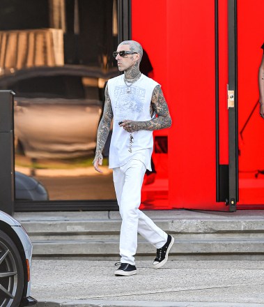 EXCLUSIVE: Travis Barker Looked Cool In White Showing Off His Toned Arms While Out With Son Landon In Calabasas, CA. The Father & Son Duo Were Spotted Leaving Travis's Recording Studio After Hours Of Recording For His Son's New Album. The Rocker Was Also Seen Getting A Special Delivery From One Of Kourtney's Assistants. 11 Jul 2022 Pictured: Travis Barker Looked Cool In White Showing Off His Toned Arms While Out With Son Landon In Calabasas, CA. The Father & Son Duo Were Spotted Leaving Travis's Recording Studio After Hours Of Recording For His Son's New Album. The Rocker Was Also Seen Getting A Special Delivery From One Of Kourtney's Assistants. Photo credit: @CelebCandidly / MEGA TheMegaAgency.com +1 888 505 6342 (Mega Agency TagID: MEGA877209_004.jpg) [Photo via Mega Agency]