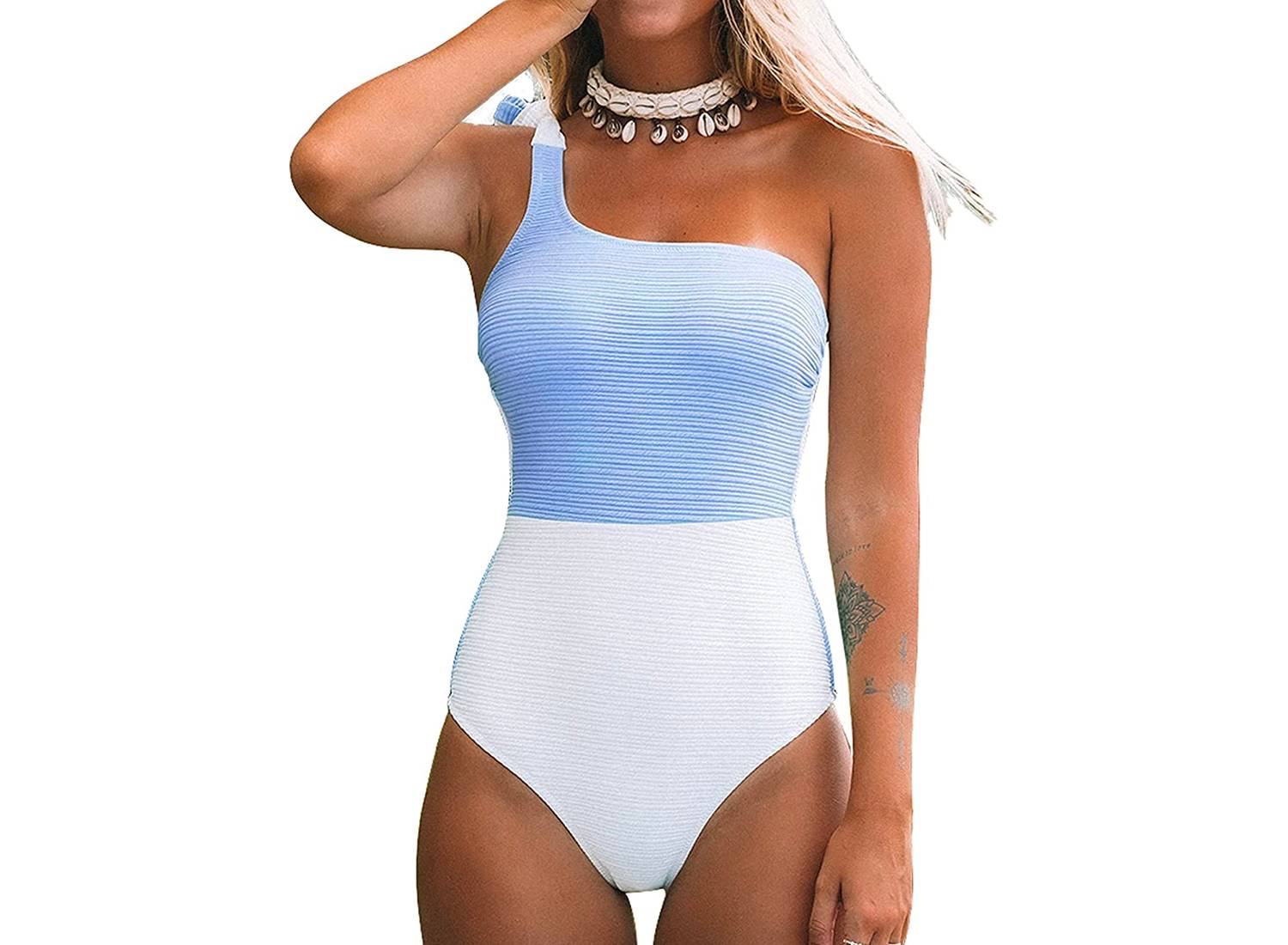 A woman wearing blue and white color block, one shoulder CUPSHE bathing suit