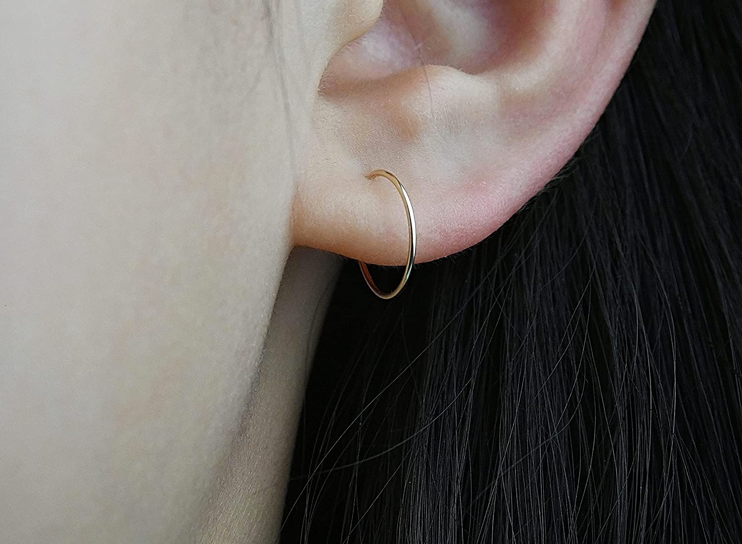 A woman wearing gold hoop earrings.