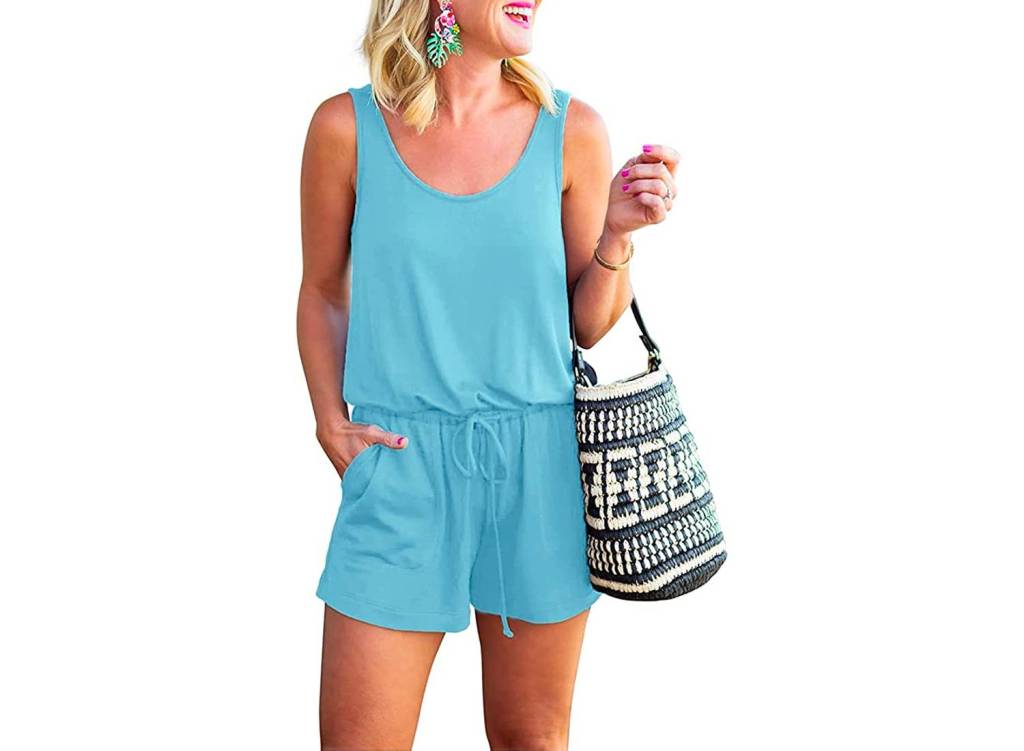 A woman wearing a light blue tank top romper with a woven bag