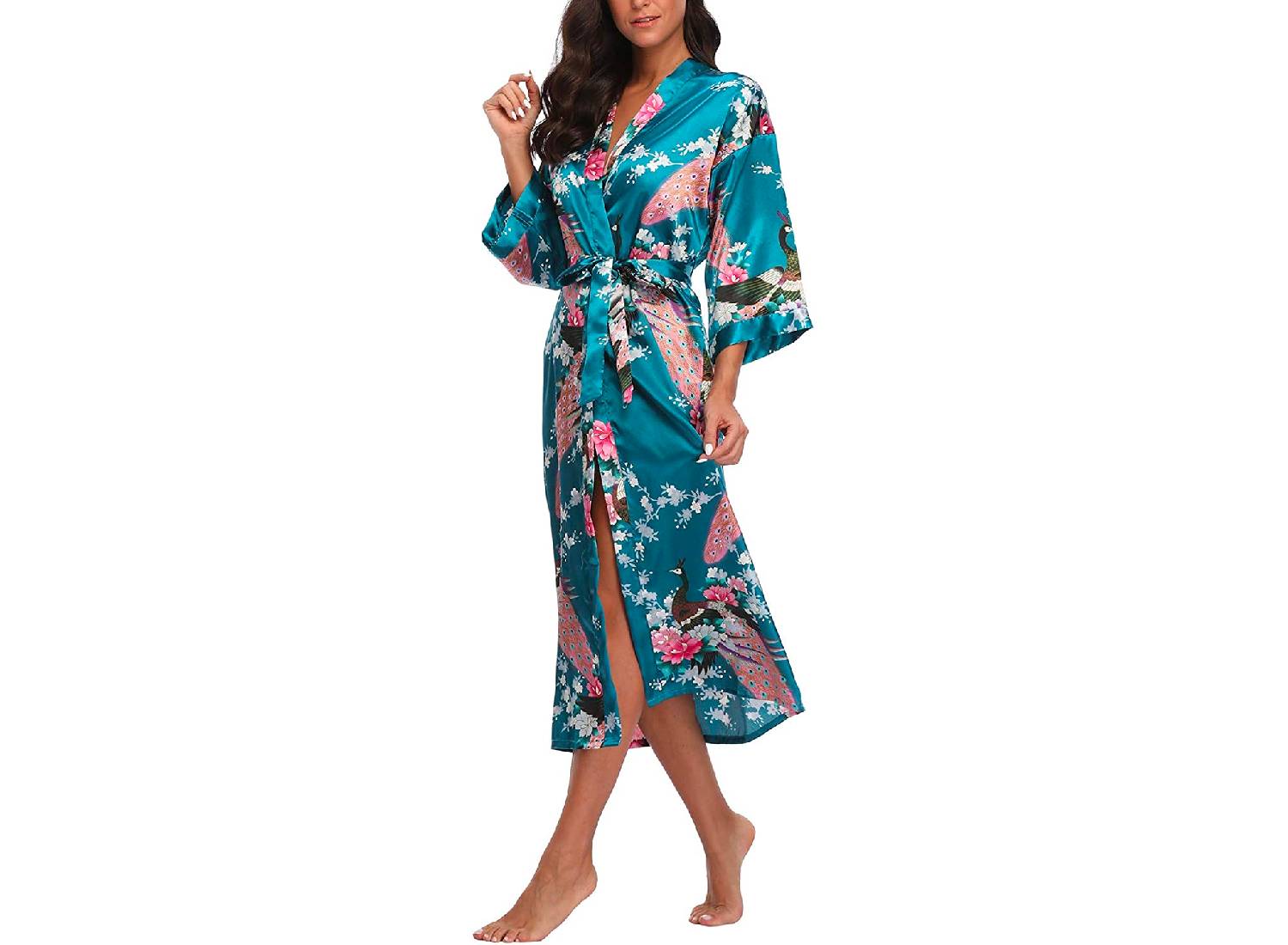 A woman wearing a teal colored robe with a peacock and pink and white blossom print