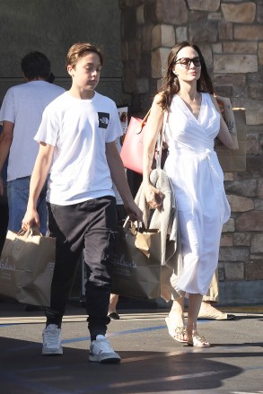 LOS FELIS, CA - *EXCLUSIVE* - Angelina Jolie looks radiant in a white dress as she leaves the grocery store with her 14-year-old son, Knox, in Los Feliz.  Knox is quite helpful in carrying groceries for mom as they return to their car.  Image: Angelina Jolie, Knox Jolie-Pitt Backgrid USA 15 August 2022 USA: +1 310 798 9111 / usasales@backgrid.com UK: +44 208 344 2007 / uksales@backgrid.com * UK Customers - Pictures with children Please face Pixelate before publication*