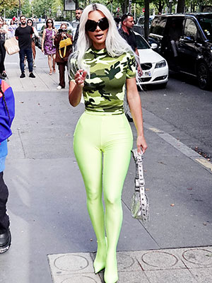 kim kardashian looks striking in a camo top and neon green