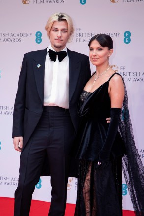 Millie Bobby Brown, kiri, dan Jake Bongiovi berpose untuk fotografer saat tiba di British Academy Film Awards ke-75, BAFTA's, di LondonBafta Film Awards 2022 Arrivals, London, Inggris Raya - 13 Mar 2022