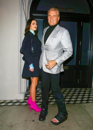 West Hollywood, CA - Actor Dolph Lundgren wears a leg brace due to an injury as he arrives with fiancee Emma Krokdal for dinner at Craig's in West Hollywood.  Photo: Dolph Lundgren, Emma Krokdal BACKGRID USA NOVEMBER 22, 2022 TRACKING NETWORK NAME MUST READ: BACKGRID USA: +1 310 798 9111 / usasales@backgrid.com United Kingdom: +44 208 344 2007 / uksales@backgrid.com *UK Customers - Images with Children Please pixelate faces before publishing*