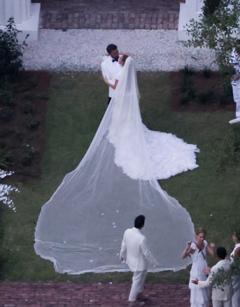 Savannah, GA - *PREMIUM-EXCLUSIVE* - And the bride was wearing... white.  Jennifer Lopez rocks a stunning white wedding dress as she celebrates her marriage to Ben Affleck, sporting a white jacket and black pants.  The couple kissed and posed for photos at Ben's $8 million mansion in Georgia on Saturday night before spending the night celebrating their love and togetherness with family and a slew of A-list friends. All The couple's children from their new blended family were also spotted on a walkway leading to Ben's plantation-style home with two of the children carrying J Lo's amazing train, now Jennifer Affleck.  Pictured: Ben Affleck and Jennifer Lopez BACKGRID USA AUGUST 20, 2022 USA: +1 310 798 9111 / usasales@backgrid.com UK: +44 208 344 2007 / uksales@backgrid.com Post *