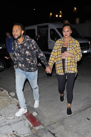 Los Angeles, CA  - *EXCLUSIVE*  - A pregnant Chrissy Teigen and John Legend hold hands as they are spotted leaving a film photoshoot in Los Angeles. The 36-year-old pregnant model is wearing black spandex with a matching black top and a yellow flannel dress shirt.  Pictured: Chrissy Teigen, John Legend  BACKGRID USA 18 OCTOBER 2022   USA: +1 310 798 9111 / usasales@backgrid.com  UK: +44 208 344 2007 / uksales@backgrid.com  *UK Clients - Pictures Containing Children Please Pixelate Face Prior To Publication*