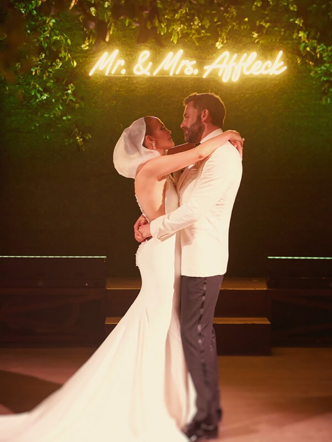 Ben Affleck & Jennifer Lopez stand in front of a ‘Mr. & Mrs. Affleck’ light