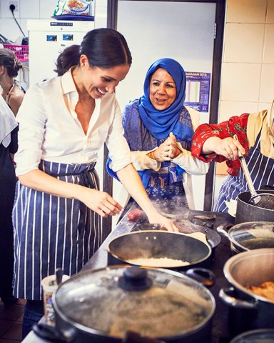 Meghan Markle, The Duchess of Sussex, cooks with women in the Hubb Community Kitchen at the Al Manaar Muslim Cultural Heritage Centre in West London, in the aftermath of the Grenfell Tower fire, which has resulted in the publications of Together: Our Community Cookbook, which features the women's own personal recipes from across Europe, the Middle East, North Africa and the Eastern Mediterranean and for which the Duchess has written the foreword in London, UK, on the 17th September 2018 Picture by Jenny Zarins/WPA Pool EDITORIAL USE ONLY, NOT FOR USE AFTER 17TH SEPTEMBER 2018. 17 Sep 2018 Pictured: Meghan Markle, Duchess of Sussex. Photo credit: MEGA TheMegaAgency.com +1 888 505 6342 (Mega Agency TagID: MEGA276694_002.jpg) [Photo via Mega Agency]