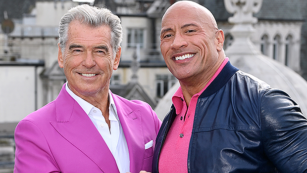 Pierce Brosnan & The Rock Match In Hot Pink Looks At ‘Black Adam’ Photocall