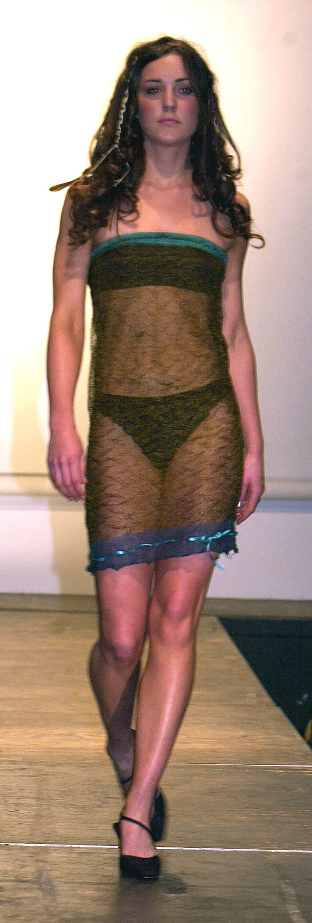 Kate Middleton en la pasarela con un vestido de encaje negro transparente sobre un sujetador bandeau y braguitas de bikini negras. Desfile de moda benéfico de la Universidad de St Andrews, Escocia, Gran Bretaña - 26 de marzo de 2002 Kate Middleton, de 19 años, amiga del príncipe Guillermo en la universidad con un vestido de encaje negro transparente sobre un sujetador bandeau y braguitas de bikini negras. Se cree que será una de sus futuras compañeras de piso en su segundo año.