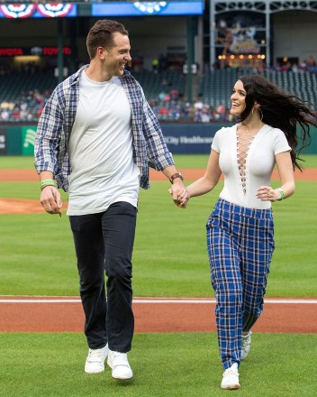 Adam Gottschalk, contestant on ABC "Bachelor"left, and Raven Gates, a contestant on "Bachelor" walks off the field after Gottschalk makes his ceremonial first pitch before a baseball game between the Texas Rangers and the Toronto Blue Jays, in Arlington, Texas.  Toronto won 8-5 Blue Jays Rangers Baseball Team, Arlington, USA - 04/06/2018