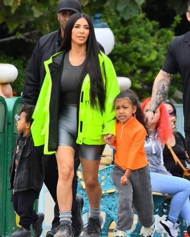 EXCLUSIVE: Kim & Kourtney Kardashian were spotted enjoying a day at Disneyland with their kids in Anaheim, CA. The famous sisters brought all of their kids including North West, Saint West, Penelope Disick, Mason Disick, and Reign Disick. Kim K was seen wearing a bright neon yellow jacket along with bike shorts from her husband’s Yeezus clothing brand. The family was seen enjoying such as Thunder Mountain Railroad, Small World, Dumbo, and the carousel. 22 May 2018 Pictured: Kim Kardashian, Saint West, North West, Kourtney Kardashian, Mason Disick, Reign Disick, Penelope Disick. Photo credit: Snorlax / MEGA TheMegaAgency.com +1 888 505 6342 (Mega Agency TagID: MEGA226927_003.jpg) [Photo via Mega Agency]