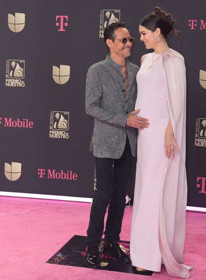 Marc Anthony holds his wife Nadia Ferreira’s baby bump