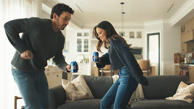 Miles Teller & Wife Keleigh Sperry Have A ‘Hold Music Dance Party’ In Bud Light’s Super Bowl Commercial