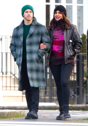 EXCLUSIVE: Nick Jonas and wife Priyanka Chopra Jonas go sightseeing around London ahead of the Christmas holidays. The couple, who have been married for two years, wore face masks and stopped for a hot drink at a cafe. The Bollywood actress who is in town to film 'Text for You', looked positively glowing. The happy couple could be seen stopping for Nick to take some funny photos of Priyanka next to a Highway Maintenance van, presumably to have the words ‘High Maintenance’ behind her. The loved up pair could be seen walking along with Priyanka’s mother in tow, always a couple of yards behind them. Nick, 28, and Priyanka, 38, could be seen wearing Christmas colors, with Nick in a green beanie hat and green accented checked woolen overcoat, while Priyanka opted for a dark brown leather jacket with red and pink knitted top, beanie hat, and jeans. 09 Dec 2020 Pictured: Nick Jonas, Priyanka Chopra Jonas. Photo credit: MEGA TheMegaAgency.com +1 888 505 6342 (Mega Agency TagID: MEGA720310_001.jpg) [Photo via Mega Agency]