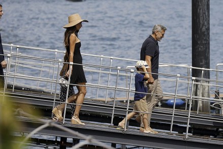 Como, ITALY  - George and Amal Clooney, along with their sleepy kids Ella and Alexander, embark on a boat trip in Como. Waving at passersby, George sports a classy look with sunglasses, a blue shirt, and khaki pants, while Amal turns heads in a sun hat and black dressPictured: George Clooney, Amal ClooneyBACKGRID USA 28 JULY 2023 USA: +1 310 798 9111 / usasales@backgrid.comUK: +44 208 344 2007 / uksales@backgrid.com*UK Clients - Pictures Containing ChildrenPlease Pixelate Face Prior To Publication*