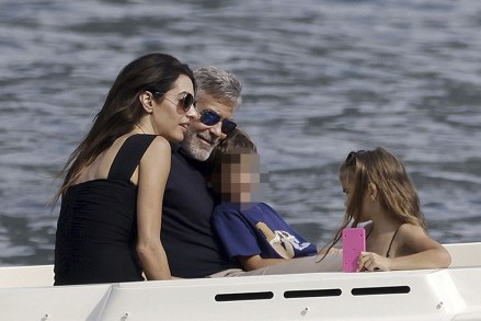 Como, ITALY  - George and Amal Clooney, along with their sleepy kids Ella and Alexander, embark on a boat trip in Como. Waving at passersby, George sports a classy look with sunglasses, a blue shirt, and khaki pants, while Amal turns heads in a sun hat and black dressPictured: George Clooney, Amal ClooneyBACKGRID USA 28 JULY 2023 USA: +1 310 798 9111 / usasales@backgrid.comUK: +44 208 344 2007 / uksales@backgrid.com*UK Clients - Pictures Containing ChildrenPlease Pixelate Face Prior To Publication*