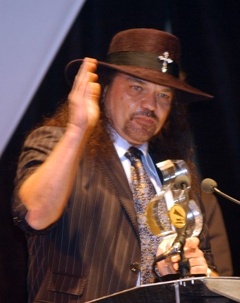 SKYNYRD Lynyrd Skynyrd group leader and founding guitarist Gary Rossington holds a trophy and addresses guests at a ceremony honoring Lynyrd Skynyrd and other recording artists in Coral Gables, Florida. The Florida chapter of the Recording Academy presented Juanes with his 2004 Florida Heroes Award. FLORIDA HEROES AWARD, Coral Gables, USA