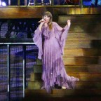 Taylor Swift sits on top of a roof on an enchanted house in a flowing purple dress as she performs in moss during her 1st night of her worldwide tour in Arizona