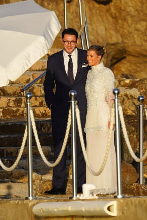 Blushing bride Sofia Richie looks radiant in an elegant white gown as she celebrates her lavish wedding weekend in the French Riviera. The model and daughter of legendary crooner Lionel Richie stepped out with her British fiance Elliot Grainge on Friday evening during their ultra glamorous trip to tie the knot in Antibes. It was unclear whether the happy couple were heading off to a fancy rehearsal dinner, or were dressed up for the nuptials. The stylish 24-year-old chose a demure, delicately beaded floor length ensemble for the occasion paired with white stilettos and wore her long hair in a chic up do. Her record executive groom, 30, looked dapper in a dark suit and tie as they were snapped by their team of photographers at their swanky hotel at sunset. Among the slew of A-list guests jetting in to watch them exchange vows are Cameron Diaz and Benji Madden, Sofia’s sister Nicole Richie and husband Joel Madden, as well as her father Lionel Richie and brother Miles. 21 Apr 2023 Pictured: Sofia Richie and Elliot Grainge at Hotel du Cap Eden Roc in Antibes. Photo credit: DALI / MEGA TheMegaAgency.com +1 888 505 6342 (Mega Agency TagID: MEGA971675_002.jpg) [Photo via Mega Agency]