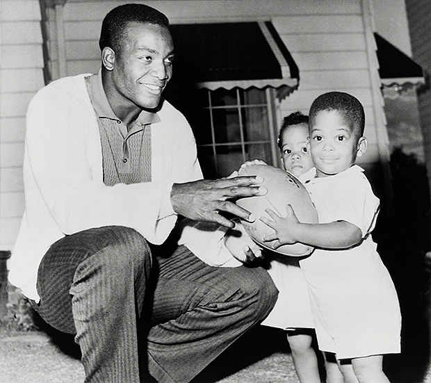 Jim Brown smiles with his twins, Kim and Kevin, in 1961