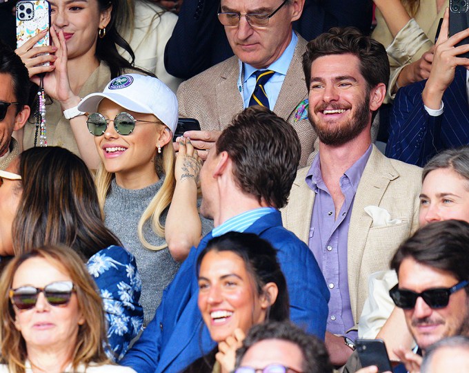 Ariana Grande & Andrew Garfield smiling in their seats