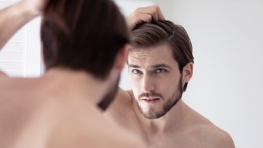 Man looking astatine  his reflection   successful  the mirror