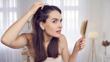 Woman examining her scalp