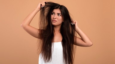 Woman looking at her dry hair