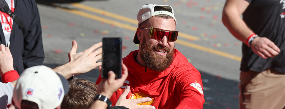 KANSAS CITY, MO - FEBRUARY 14: Travis Kelce smiles and high fives with fans during the Kansas City Chiefs Super Bowl LVIII Victory Parade on Feb 14, 2024 in Kansas City, MO. (Photo by Scott Winters/Icon Sportswire via Getty Images)