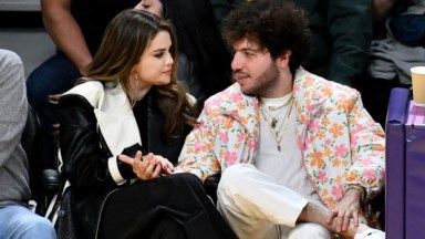 Selena Gomez and Benny Blanco holding hands at a basketball game