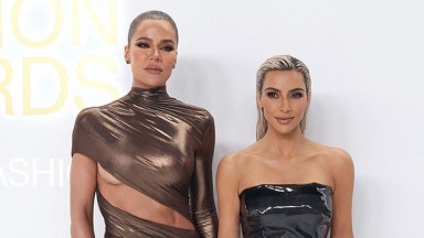 Khloe Kardashian and Kim Kardashian posing at an event.