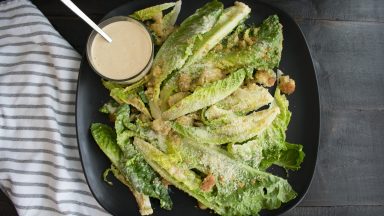 Caesar salad and dressing on a serving plate