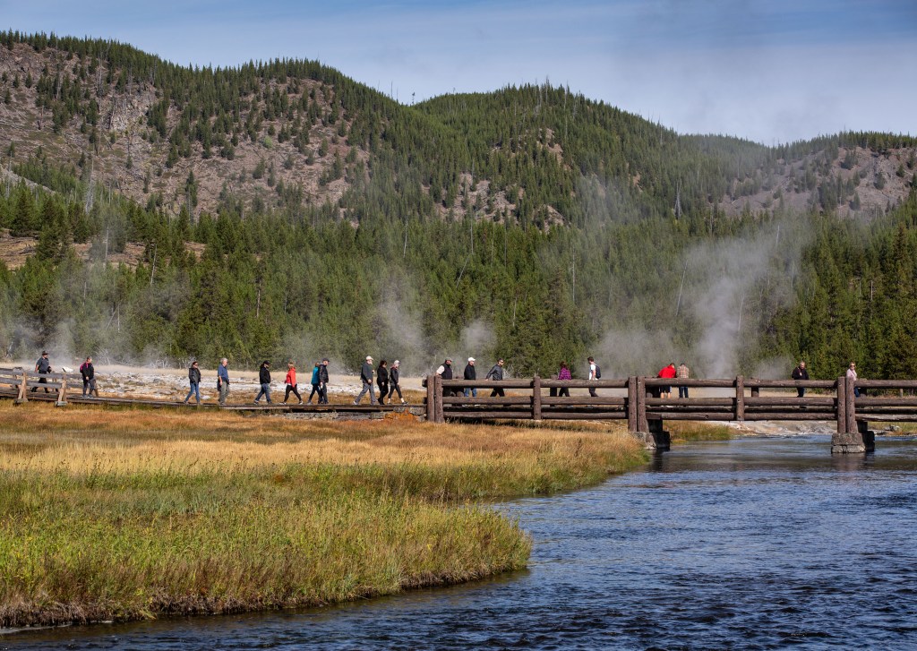 YELLOWSTONE NATIONAL PARK, WY - SEPTEMBER 18: The boardwalk across the Firehole River in Yellowstone National Park's Biscuit Basin is viewed on September 18, 2022, in Yellowstone National Park, Wyoming. Sitting atop an active volcanic caldera, Yellowstone, America's first National Park, is home to more geological hydrothermal features (geysers, mud pots, hot springs, fumaroles) than are found in the rest of the world combined. (Photo by George Rose/Getty Images)