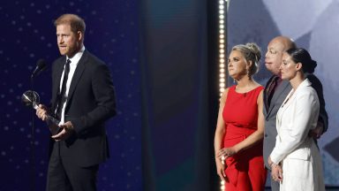 Prince Harry, Duke of Sussex accepts the Pat Tillman Award onstage from Kirstie Ennis, Israel Del Toro and Elizabeth Marks