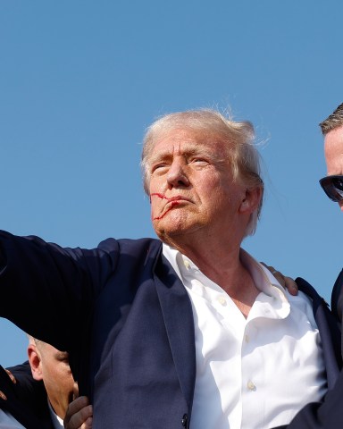 BUTLER, PENNSYLVANIA - JULY 13: Republican presidential candidate former President Donald Trump pumps his fist as he is rushed offstage during a rally on July 13, 2024 in Butler, Pennsylvania. (Photo by Anna Moneymaker/Getty Images)