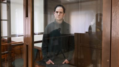 US journalist Evan Gershkovich, arrested on espionage charges, looks out from inside a defendants' cage before a hearing to consider an appeal on his extended pre-trial detention, at the Moscow City Court in Moscow on February 20, 2024. Wall Street Journal reporter Evan Gershkovich was detained last March on spying charges during a reporting trip to the Urals. (Photo by NATALIA KOLESNIKOVA / AFP) (Photo by NATALIA KOLESNIKOVA/AFP via Getty Images)