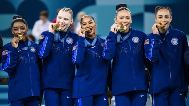 PARIS, FRANCE - JULY 30: (L-R) Simone Biles, Jade Carey, Jordan Chiles, Sunisa Lee and Hezly Rivera of Team United States celebrate on the podium for winning the gold medal during the medal ceremony for the Artistic Gymnastics Women's Team Final on day four of the Olympic Games Paris 2024 at the Bercy Arena on July 30, 2024 in Paris, France. (Photo by Tom Weller/VOIGT/GettyImages)